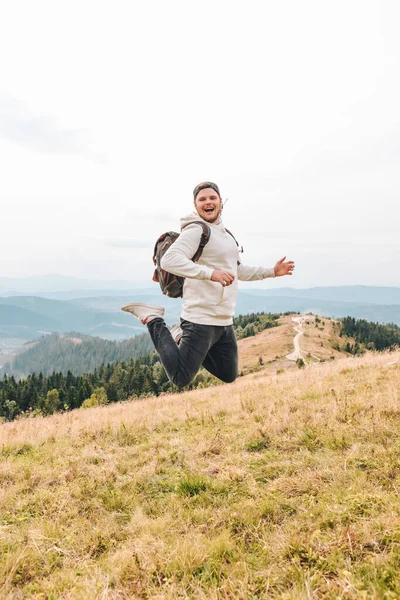 Homme avec sac à dos heureux saut sur le pic sur le mont — Photo