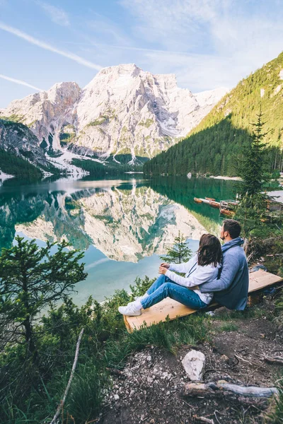 Çift bankta oturmuş dağlardaki göle bakıyor. — Stok fotoğraf