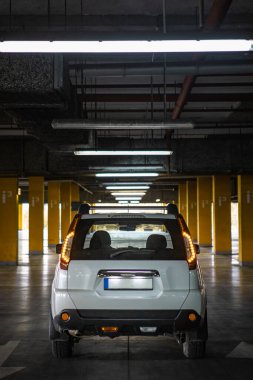 Yeraltı otoparkında beyaz bir cip. şehir yaşam tarzı. Boşluğu kopyala