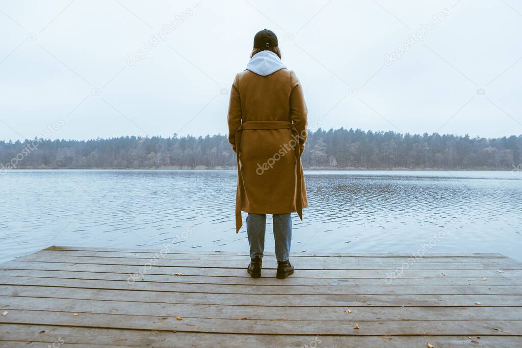 autumn lake season woman in coat at wooden pier fall