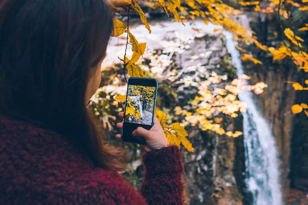 Kadın Telefon Yürüyüşü Konseptiyle Sonbahar Şelalesinin Fotoğrafını Çekiyor — Stok fotoğraf