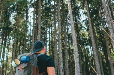 Sırt çantalı bir adam orman yürüyüşü konseptine götüren taş merdivenlerde yürüyor.