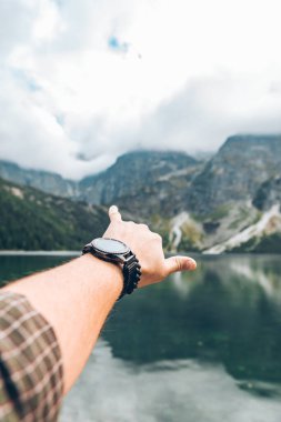 Adamın eli dağlardaki güzel gölü gösteriyor. Poland Tatra.
