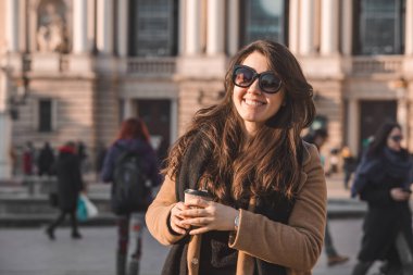 Dış mekanda kahve içen şık ve güzel bir kadının portresi.
