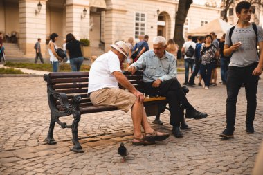 Lviv, Ukrayna - 18 Eylül 2018: İki yaşlı adam yazın şehir bankında açık havada satranç oynuyor.