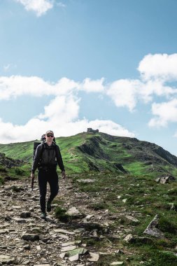 Dağlardaki genç yürüyüşçü. Yaz yürüyüşü yolu. Boşluğu kopyala.