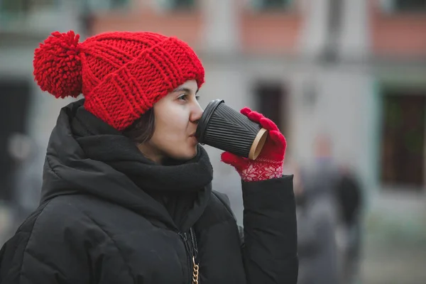 모자를 야외에서 커피를 마시는 아름다운 아가씨 — 스톡 사진