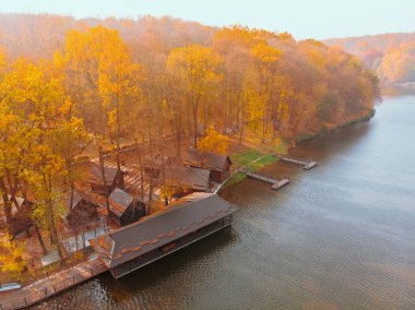 Göl kenarındaki sonbahar orman parkının havadan görüntüsü. İskeleler de bbq bölgesinde dinleniyor.