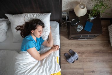 Beyaz arka planda uyuyan bir kadın. Genç kadınlar. ev hayatı. en üstteki görünüm