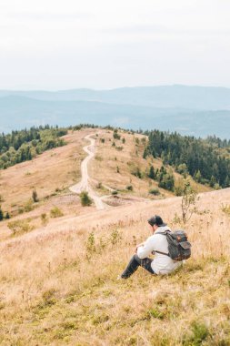 Sırt çantalı adam sonbahar dağlarında yürüyüş yapıyor. Kopya alanı.