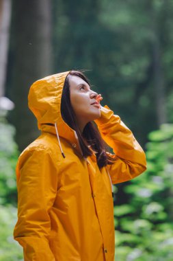 Sarı yağmurluklu kadın yağmurlu ormanda yürüyor. Dikiz aynası. kopyalama alanı. Büyük dünyadaki küçük insanlar.
