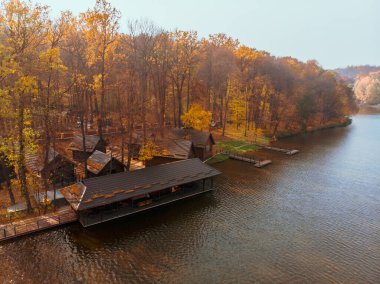 Göl kenarındaki sonbahar orman parkının havadan görüntüsü. İskeleler de bbq bölgesinde dinleniyor.