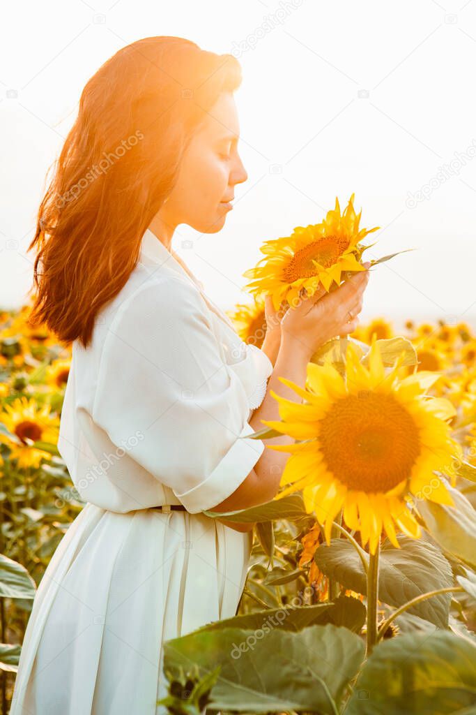 young beautiful woman at sunflowers field on sunset. lifestyle activities