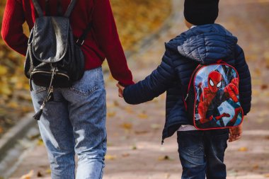 Lviv, Ukrayna - 24 Ekim 2019: çocuklu anne sonbahar parkında yürüyor. Boşluğu kopyala