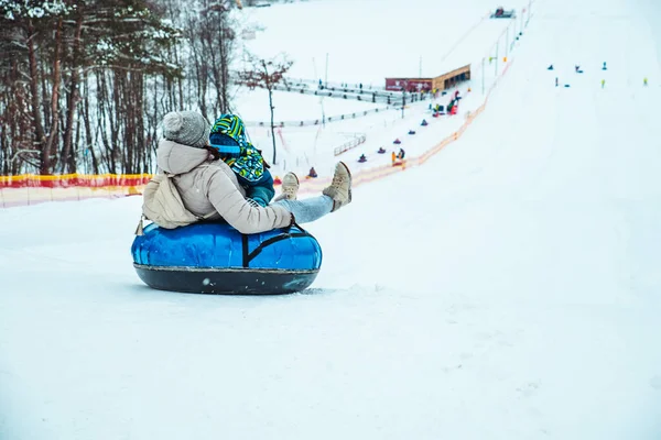 Forelder Med Barn Som Sklir Ned Snødekt Bakke Med Snørr – stockfoto