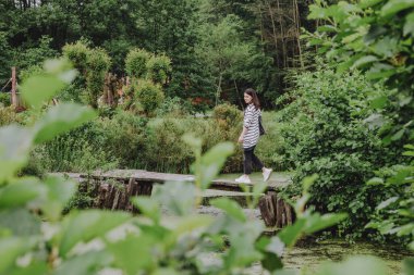 Park köprüsünün yanından geçen genç ve güzel bir kadın.