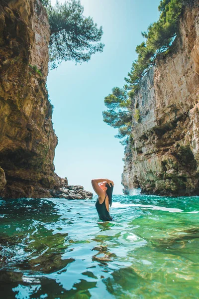穿着黑色泳衣 身披浅蓝色海水的性感年轻女子塑造了夏季海滨度假 — 图库照片