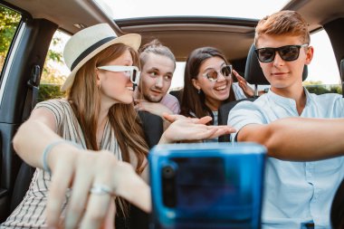 Araç navigasyonunda dört arkadaş telefonda. Yol gezisi