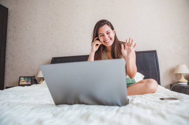Genç ve güzel bir kadın bilgisayardan görüntülü konuşma yapıyor. Online randevu. Boşluğu kopyala