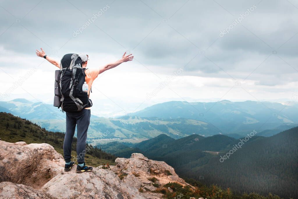 young hiker man in mountains. summer trekking path. copy space.