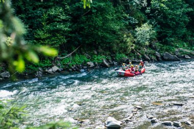 Dzembronia, Ukrayna - 1 Ağustos 2020: dağ nehri kıyısında rafting yapan bir grup insan. Boşluğu kopyala.