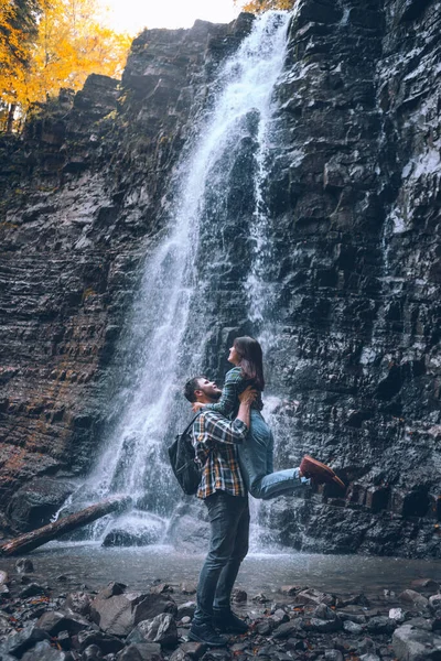Casal na frente da temporada de outono cachoeira — Fotografia de Stock