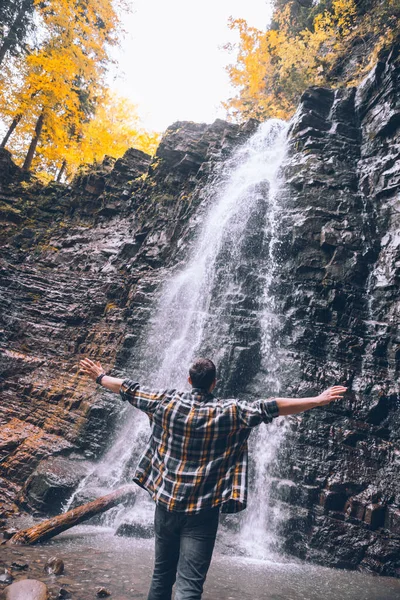 Caminhante homem olhando para cachoeira outono — Fotografia de Stock