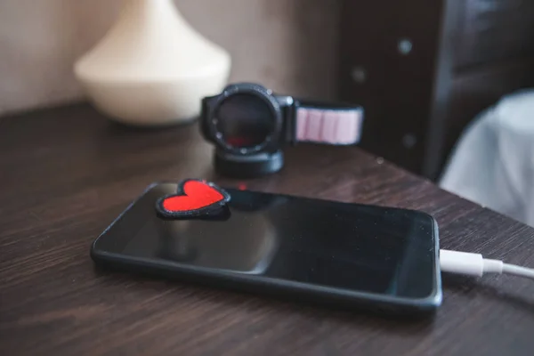 带有智能手表充电的智能手机 红色爱情之心的象征 网上约会 复制空间 — 图库照片