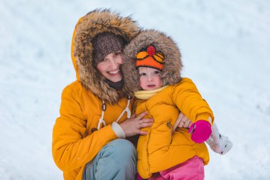 Anne ve kızı karlı tepe mevsiminde kayıyor.