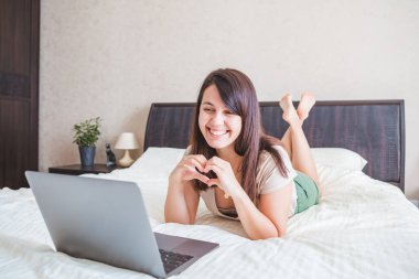 Genç ve güzel bir kadın bilgisayardan görüntülü konuşma yapıyor. Online randevu. Boşluğu kopyala
