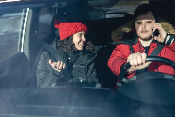 couple in car in winter outfit driving and talking rent a car