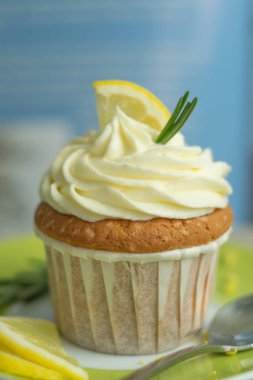 Makro gıda fotoğraf peynir kremaile yeşil tabakta lezzetli pasta limon cupcake, lor dolgu, limon dilim, keten tekstil de mavi arka planda biberiye parçaları, seçici odak, yakın, kopya alanı, bokeh, kahvaltı kahve zaman sırasında, yumuşak