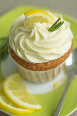 Yeşil plaka peynir krem limon cupcake güzel gıda fotoğraf, lor, limon dilimi ile süslenmiş, kaşıkla yeşil arka planda biberiye parçaları, seçici odak, yakın, kopya alanı, bokeh