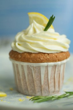 Ev yapımı fırın tatlılar peynir kremaile makro lezzetli güzel tatlı limon cupcake, lezzet, limon dilimi, parchament arka plan ile coloreful plaka biberiye ile dekore edilmiş, seçici yumuşak odak, yakın, kopya alanı