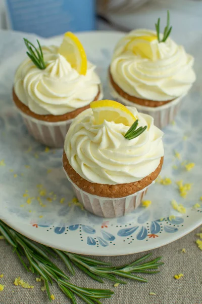 Taze fırın tatlılar tarifi kitap kapak tatlı limon cupcakes peynir krema, limon dilim, çuval bezi de mavi plaka parşömen backgroud yeşil biberiye dalları, seçici odak, yakın, kopya alanı,