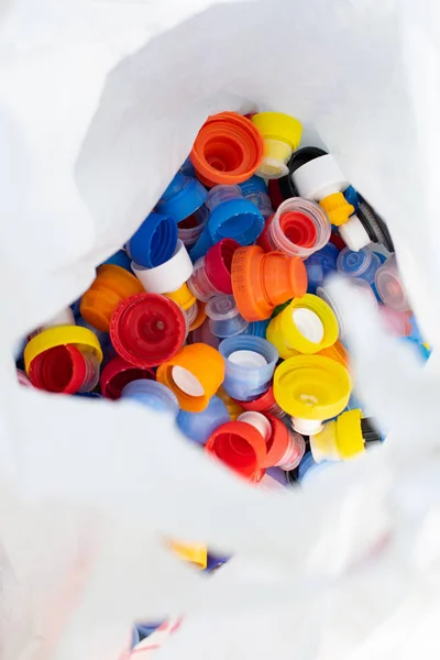 Beyaz viyolonsel paketi renkli plastik şişe kapakları ile eko friedly kavramı arka plan geri dönüşüm