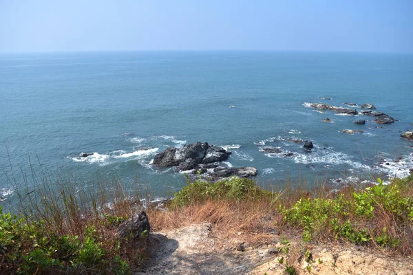 Vista alta horizonte hermoso fondo de paisaje marino azul profundo con horizonte sin fin en la playa de Goa, India, costa rocosa y vegetación — Foto de Stock