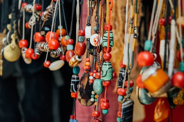 Asian traditional market with colorful gems and beads, amulets and decorations hanging in the indiand shop for tourists