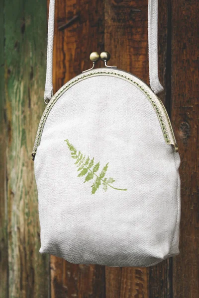 Natural linen handmade bag cloth or grid and fern pattern textile texture , craft handmade at old aged fence background