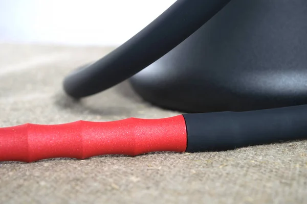 Kopya alanı, yakın çekim ile tuğla duvar grunge arka planda demir masa örtüsü ile kaplı masada kırmızı kabartma boru ve siyah kase ile bir nargile