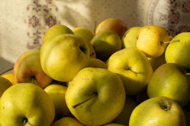 Masadaki tabakta olgun sarı elmalar