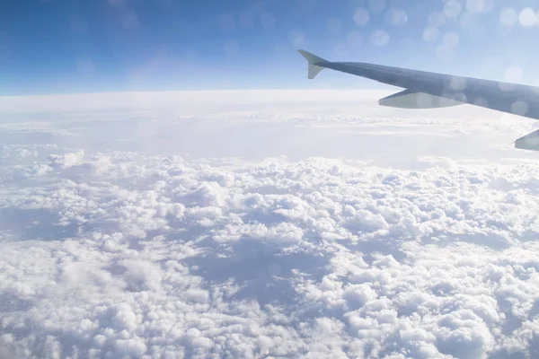 Gökyüzünde, bulutlar ve uçak kanatları, uçak penceresinden manzara