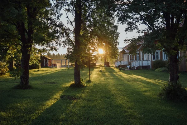 Pátio ensolarado, árvores, bela casa, gramado e casota, noite de verão em Multia, Finlândia — Fotografia de Stock