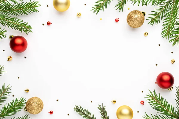 Noel çerçevesinde köknar ağacı dalları ve beyaz arka planda şenlikli süslemeler. Noel düzlüğü metin için boşluk ile yatıyordu.