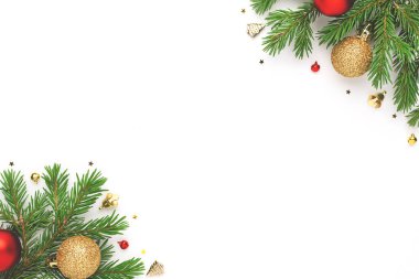 Noel çerçevesinde köknar ağacı dalları ve beyaz arka planda şenlikli süslemeler. Noel düzlüğü metin için boşluk ile yatıyordu.