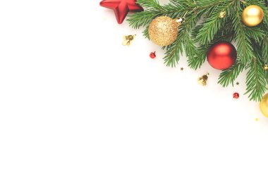 Noel çerçevesinde köknar ağacı dalları ve beyaz arka planda şenlikli süslemeler. Noel düzlüğü metin için boşluk ile yatıyordu.