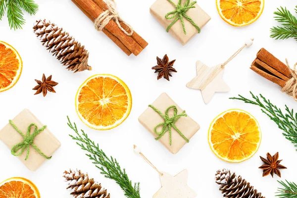 Zero waste christmas composition with fir tree, dry orange, thuja, cinnamon sticks, pine cones, star anise, and wooden stars on white background.