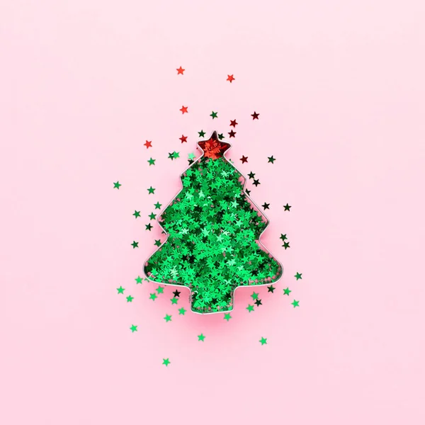 Árbol de Navidad hecho de forma de galleta y confeti verde sobre fondo rosa pastel. Concepto creativo de decoración festiva. — Foto de Stock