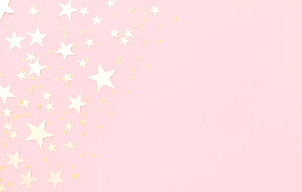 Pembe pastel renkli arka plan, yıldız şeklinde parlayan altın konfetisi..