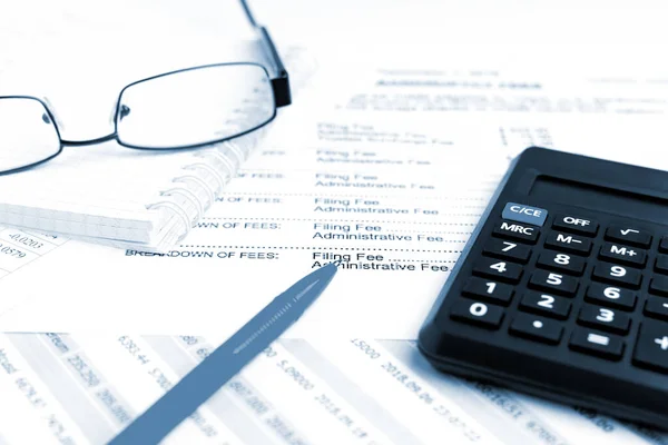 Finansal konsept. Finansal raporda kalem, hesap makinesi ve gözlükleri kapat.